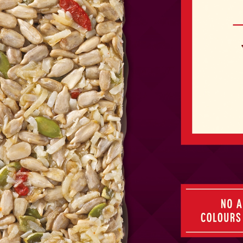 A close-up of a Paleo Nut Bar with a variety of seeds and nuts, including sunflower seeds, pumpkin seeds and goji berries.