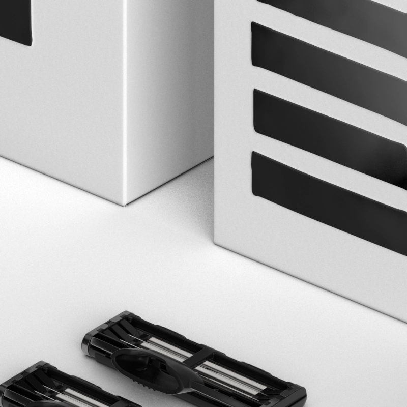 A black razor, four razor blades and two boxes of razor blades.